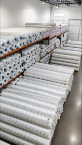 Artificial turf rolls stocked inside the No Limit Turf warehouse in Mesa, Arizona, ready for custom cutting, pickup and statewide delivery.